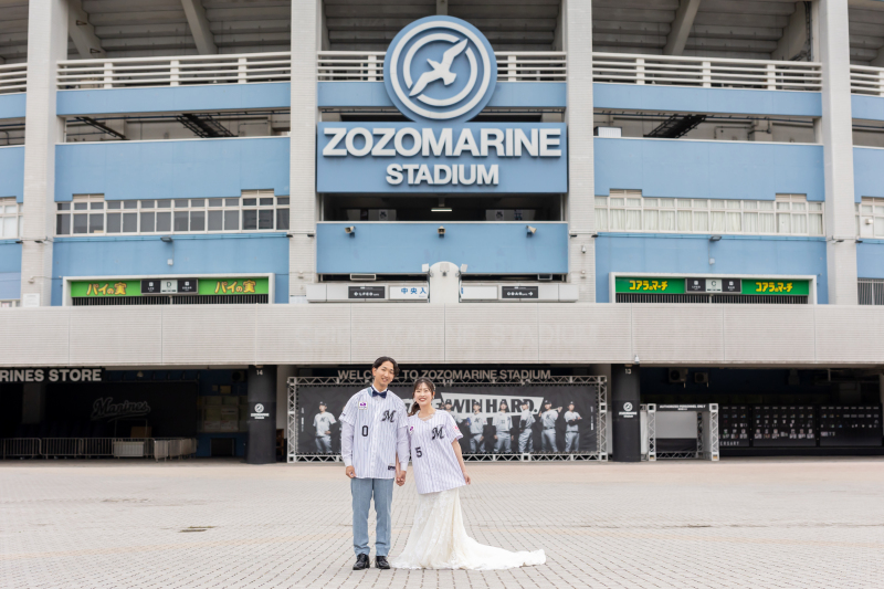 スタジアムの前で誓うユニフォーム姿の結婚写真
