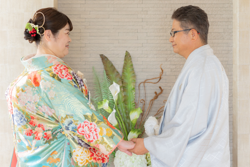手を取り合い微笑み合う温かな和装姿
