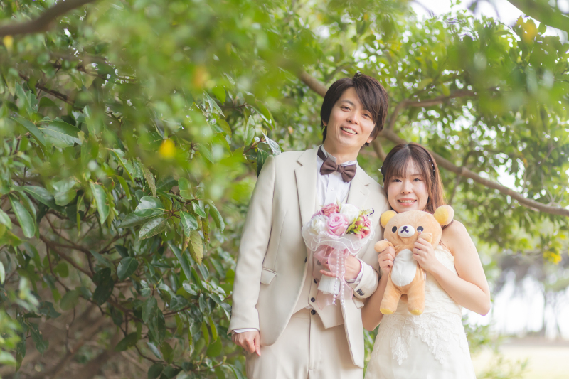 豊かな緑に包まれて、ぬいぐるみと笑顔の2人
