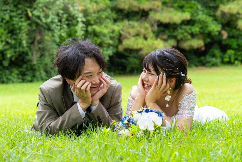 芝生に寝転ぶキュートな頬杖ポーズ