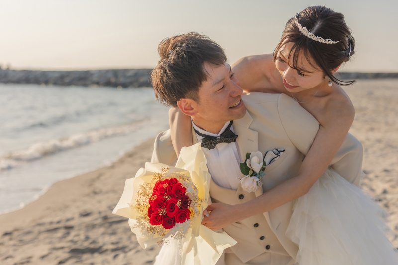 夕暮れの海辺で、笑顔重なるおんぶショット。