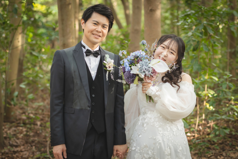ブーケから覗く笑顔、緑広がる森のフォト。