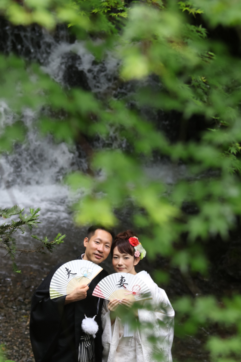 夫婦の扇子を持って