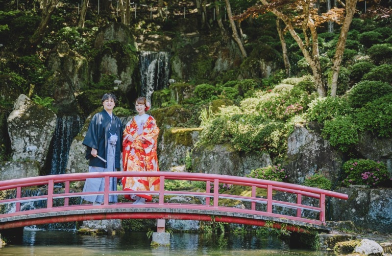 佐賀の慧洲園で。滝をバックに赤い橋で立ち姿