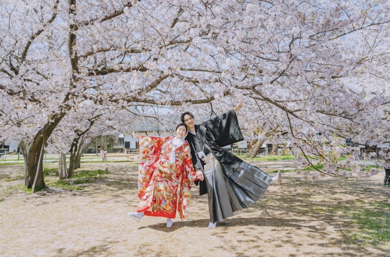 躍動感たっぷり!桜並木をバックに喜びを表現