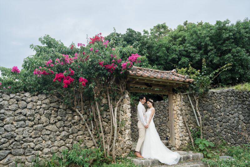 石垣とブーゲンビリアの前で