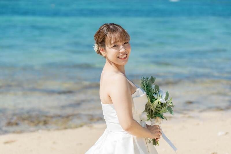 青い海を背景に新婦様の美しいバストアップ