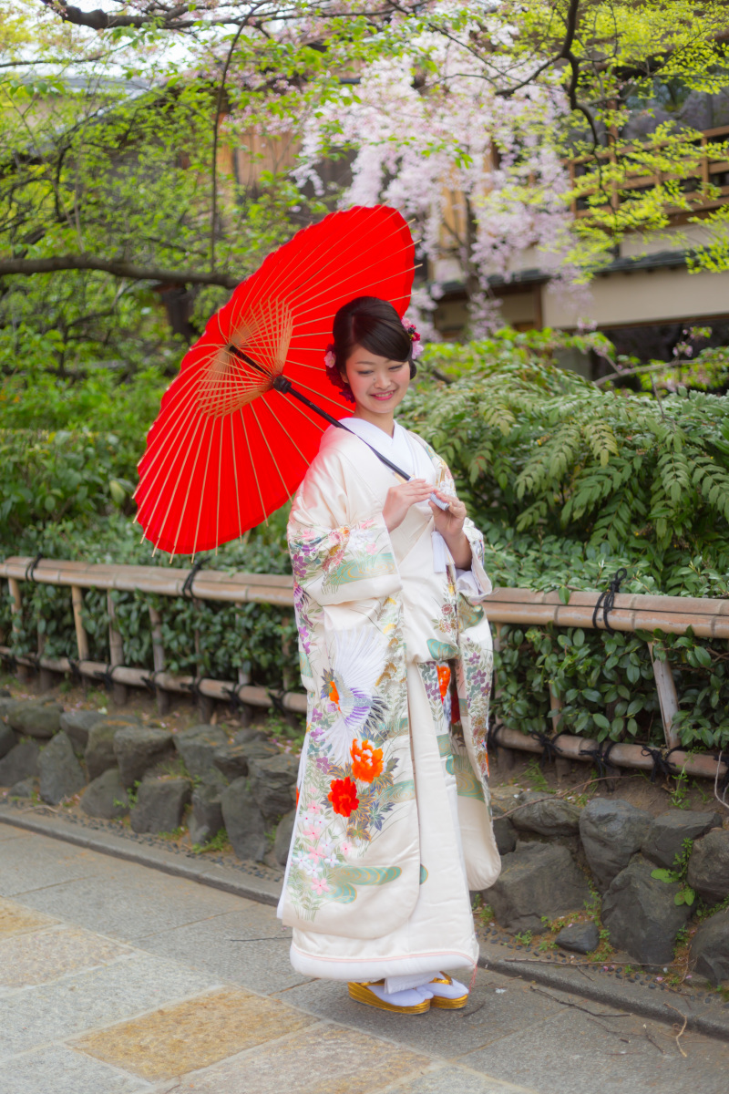 赤い色の和傘を持って