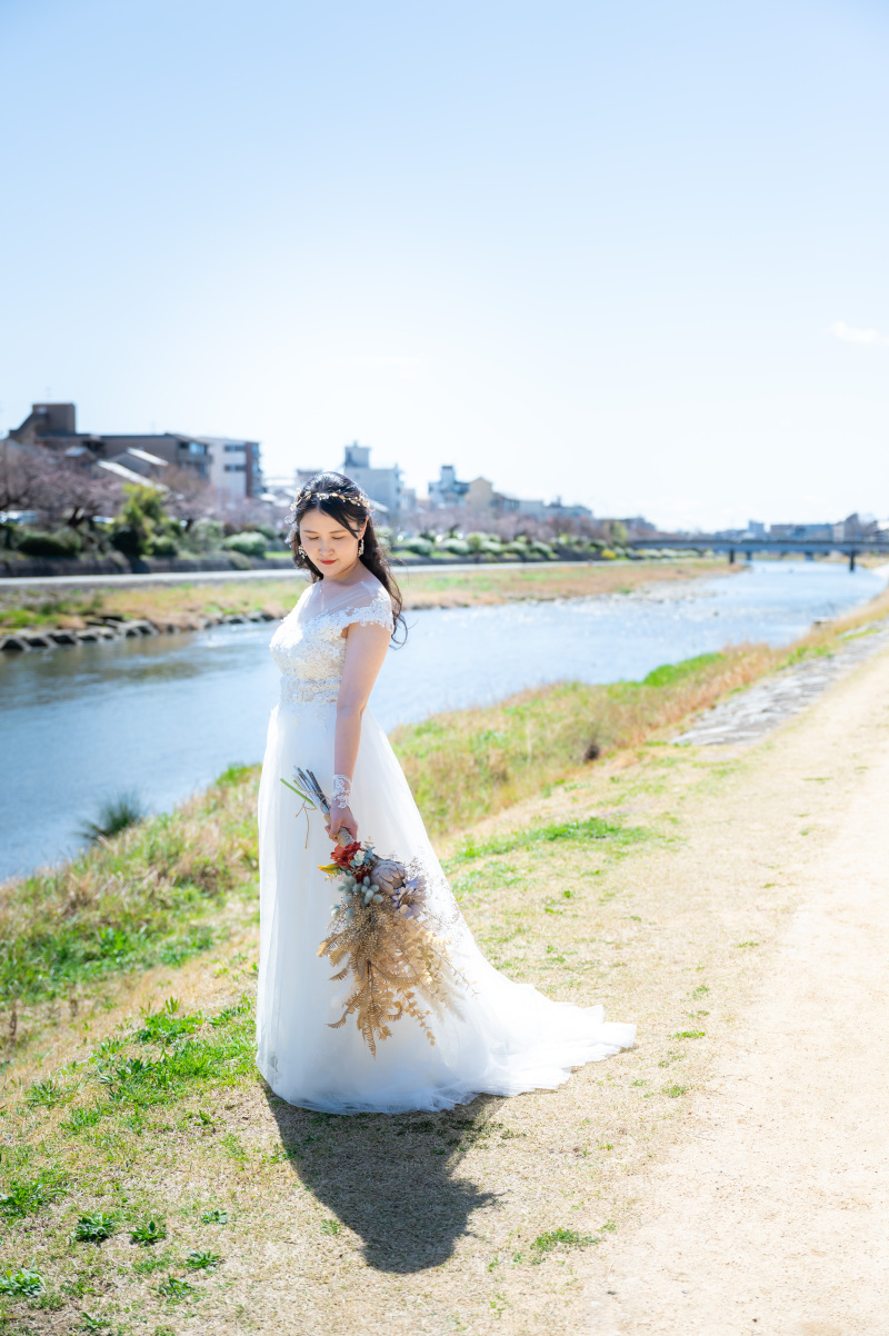青空の元水ぬるむ鴨川での新婦様お一人ショット！