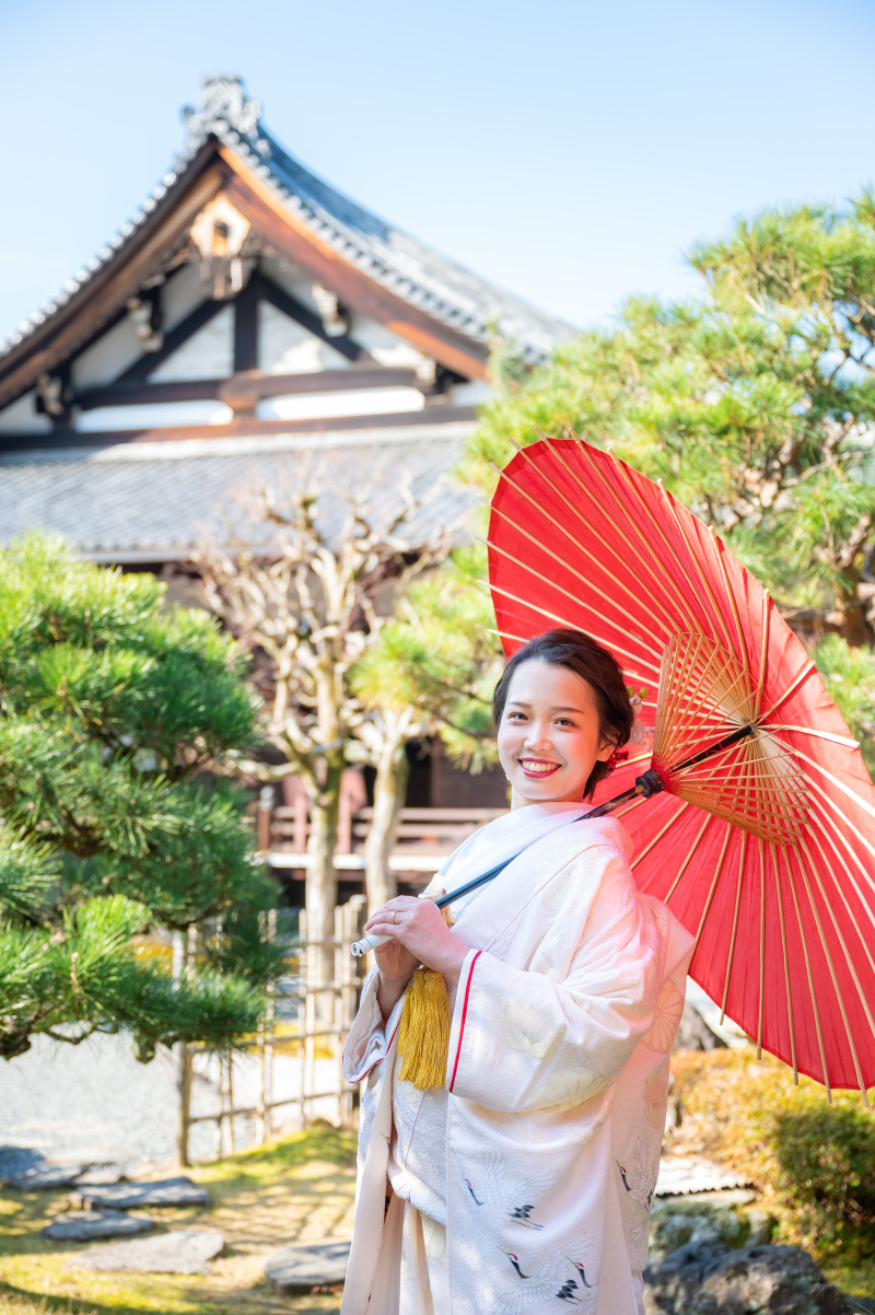 松の木の緑と赤色の和傘が良くお似合いの笑顔!