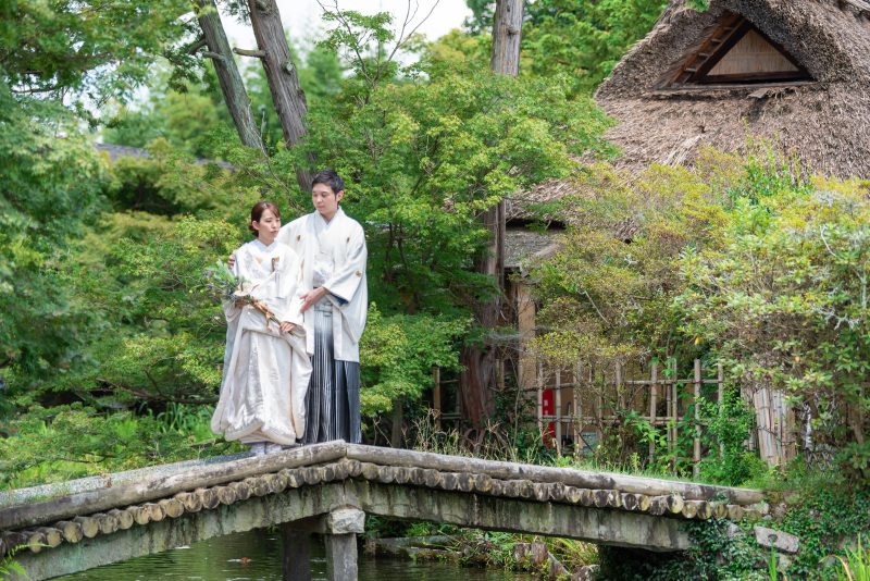 池にかかる橋は背景にかやぶきの茶屋があります。