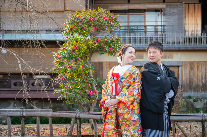 満開の寒椿の前で背中合わせのポーズ