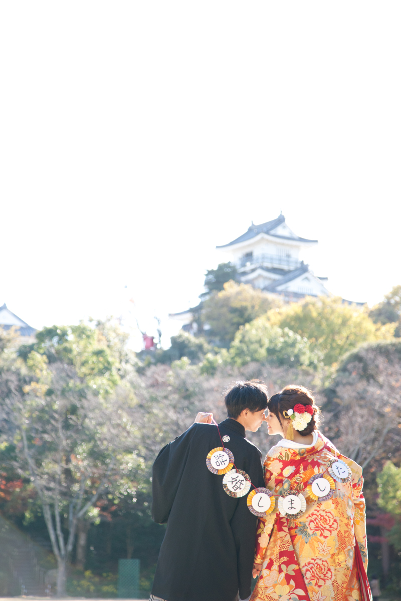 お城をバックに「結婚しました」を持って♪