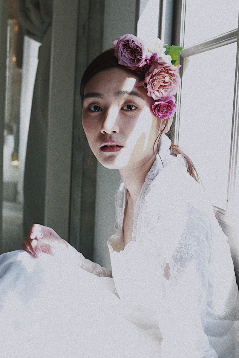 シンプルにひとつに結んだヘアに生花を使ったスタイリング。レースのヴィンテージドレスでアンティークな雰囲気に。自然光を使って、ナチュラルでみずみずしい透明感を出しました。