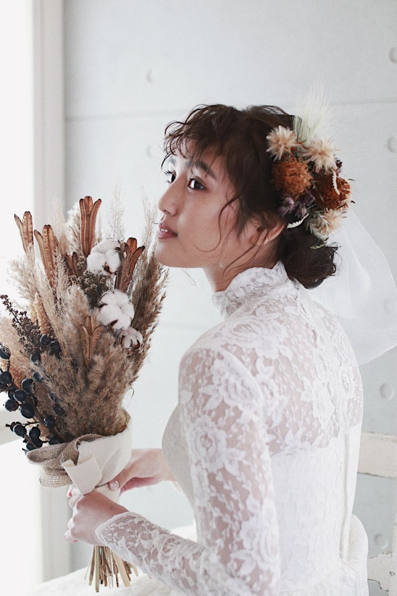 ドライフラワー×ウィンテージドレス。ヘアは前髪を巻いたり波ウェーブでクシャっとさせ後ろはゆるふわに。頬にはそばかす、リップにはヌーディなオレンジベージュ。首元まであるレースがエレガントです。