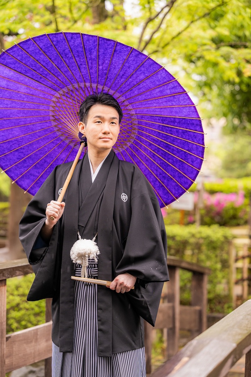 紫の和傘が彩る紋付袴姿を庭園で残した一枚