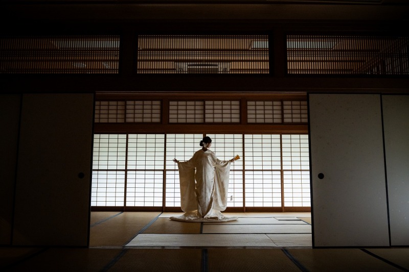静かな茶室で障子の光に浮かぶ、白無垢姿のご新婦様