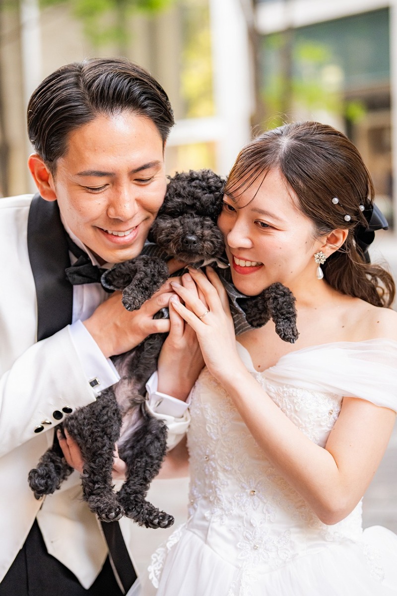 愛犬を囲んで笑顔あふれる家族のワンシーン