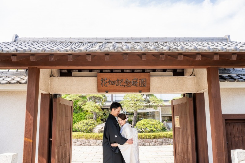 庭園の門前で寄り添う、穏やかな和装姿をお写真に。