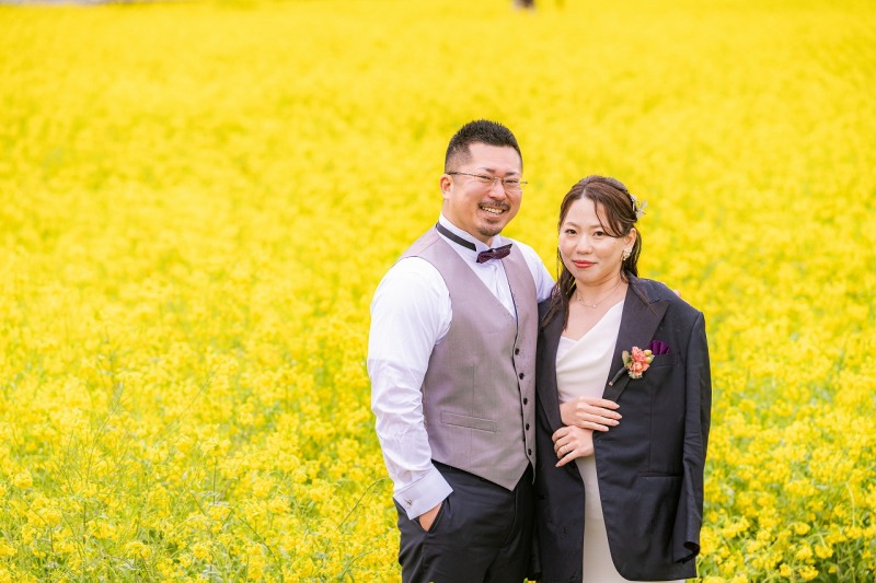 菜の花畑に映える自然な笑顔と春の彩り