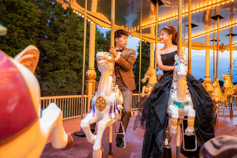 灯りに包まれるメリーゴーランドで見つめ合うふたり