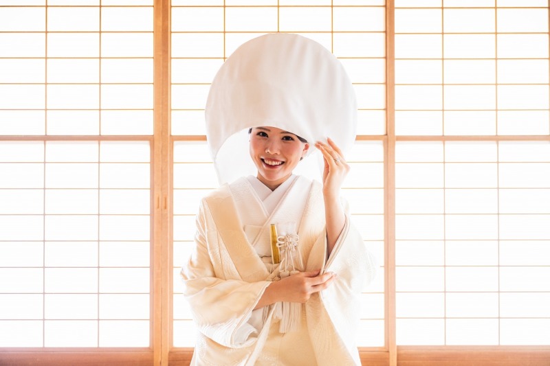 柔らかな光に包まれ、綿帽子を身につけたご新婦様。
