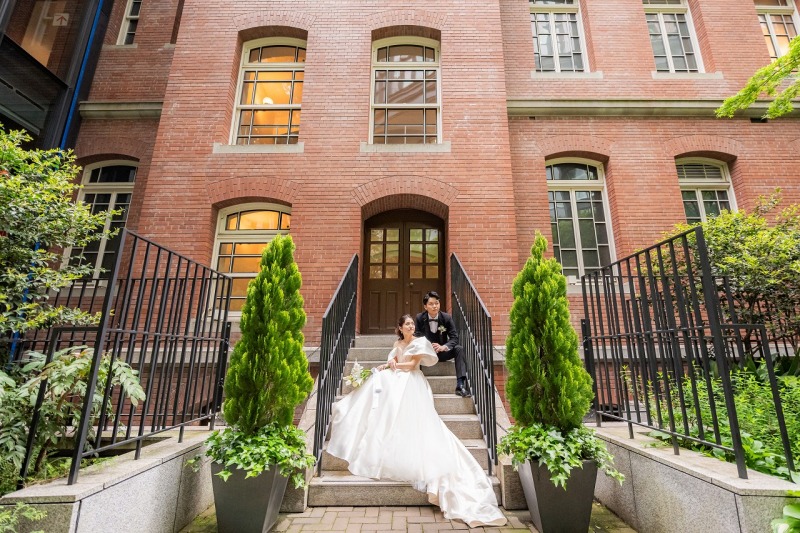 赤レンガを背景に、まるで映画のワンシーン