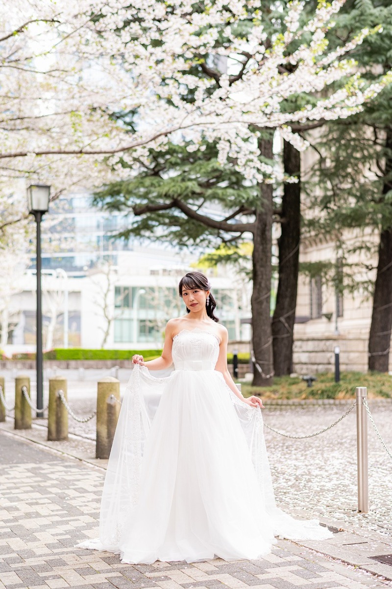 春風を感じる桜並木でご新婦様のソロショット