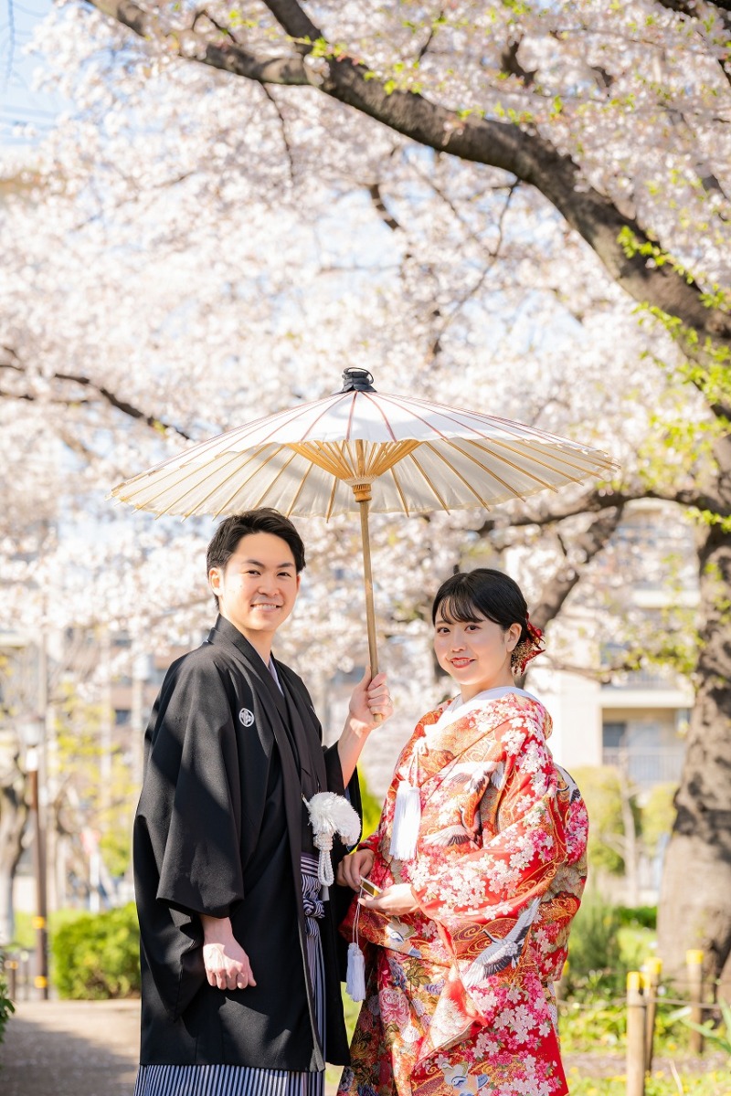 春風を感じる桜並木で向かい合いながらの記念写真。