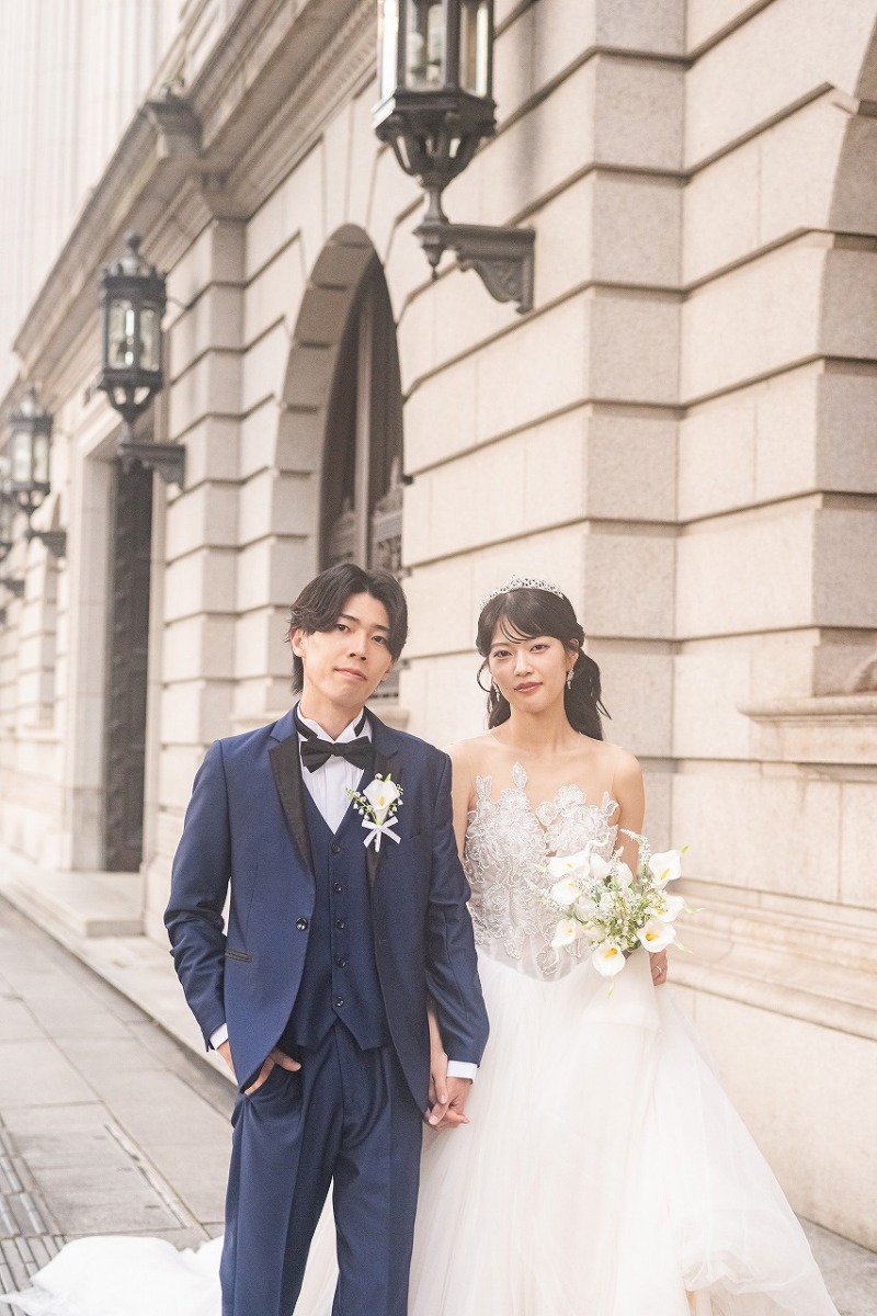 手をつないで並ぶふたりを街並みとともに