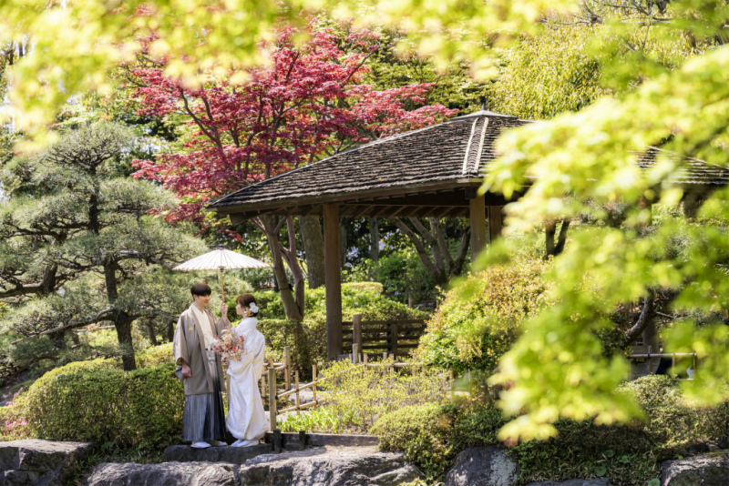 木々に囲まれ、傘を差し