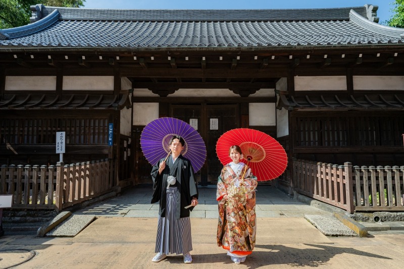 歴史ある門前に映える、和傘と和装の美しさを1枚に