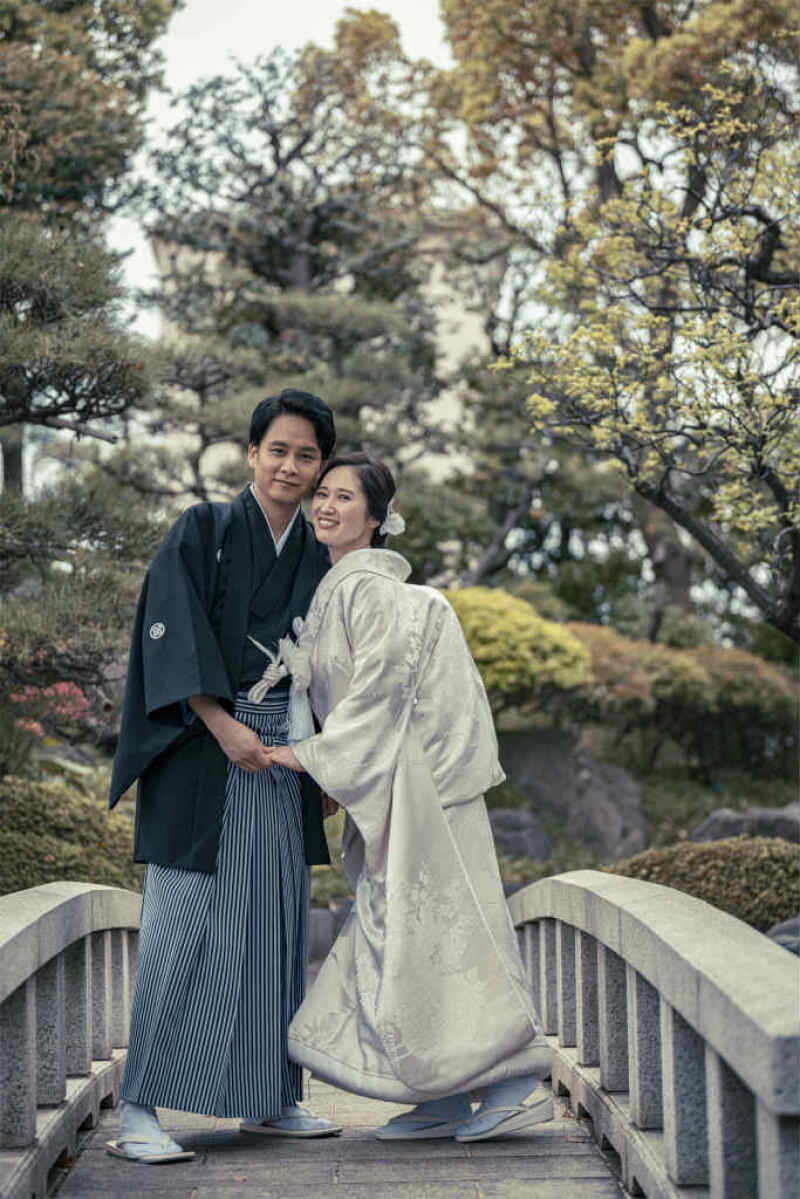 庭園の石橋の上で寄り添う和装写真