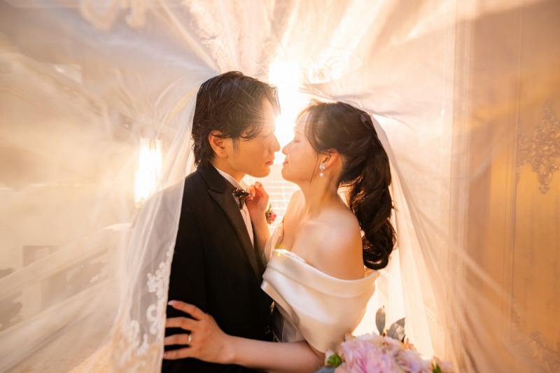 ベールとやわらかな光に包まれてそっと近づくふたり