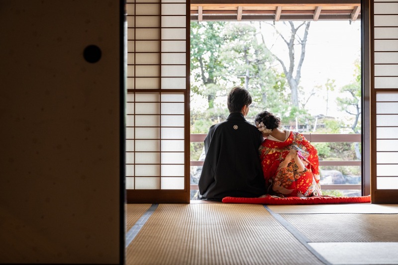 縁側で肩を寄せ合いながら庭園を眺める穏やかな一枚
