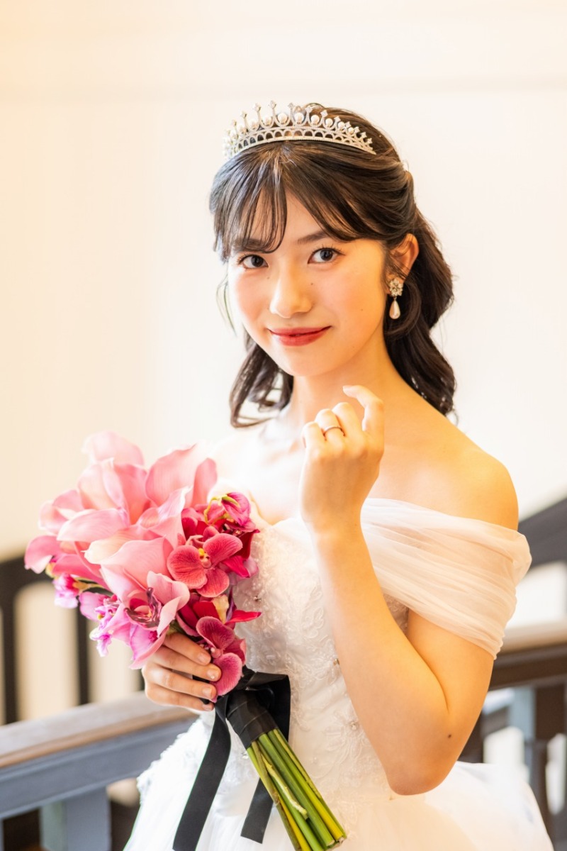 ピンクのブーケを手に微笑むご新婦様のソロショット