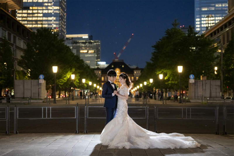 東京駅を背に手を取り合って