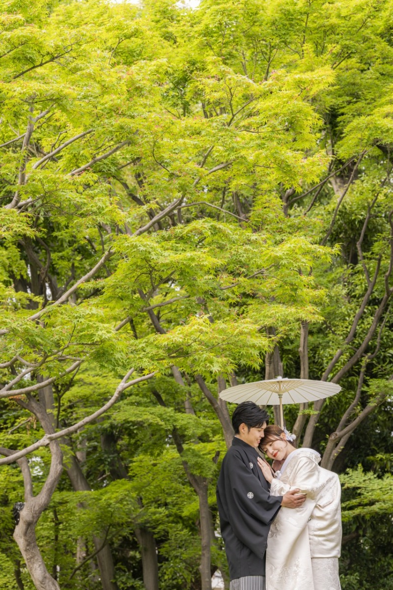 新緑のなか、番傘の下でそっと寄り添う和装ショット