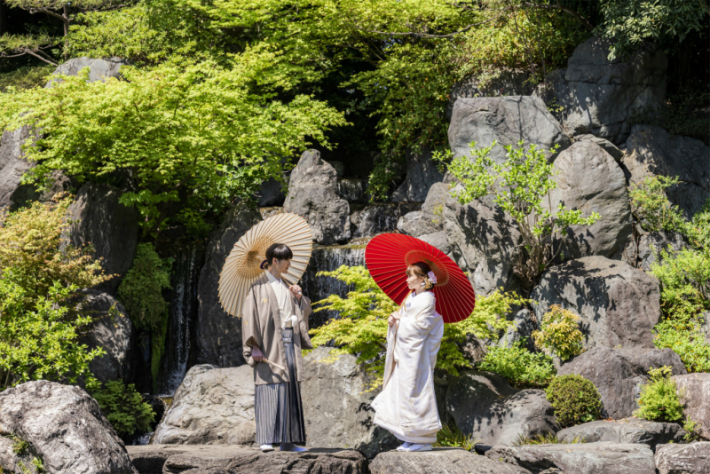 岩場で傘を差し見つめ合う