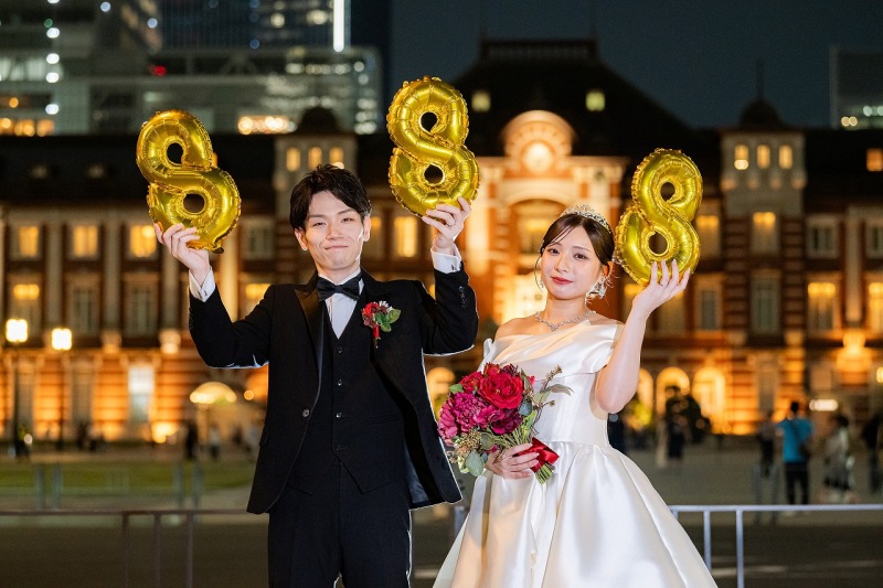 東京駅を背景に「888」のバルーンと記念ショット