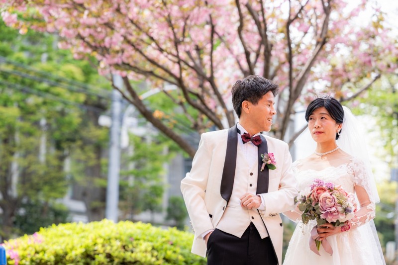 挙式前に満開に咲き誇る八重桜の下でふたりの写真を