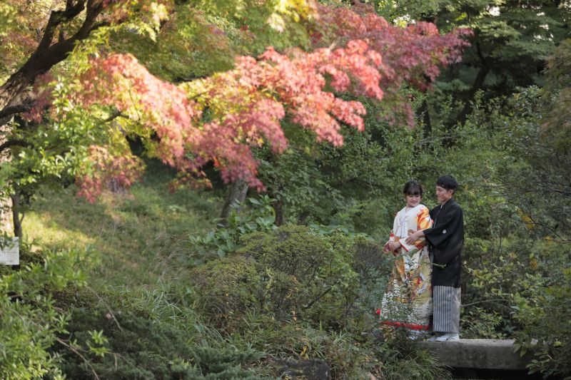 泉のまわりの紅葉とおふたり
