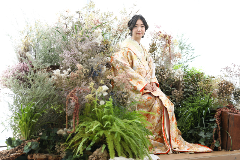 花畑の中のベンチにちょこんと座って