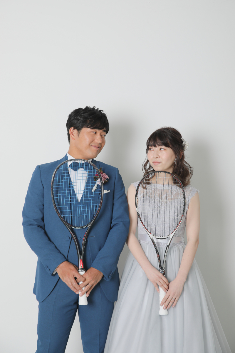 テニスラケットを持って