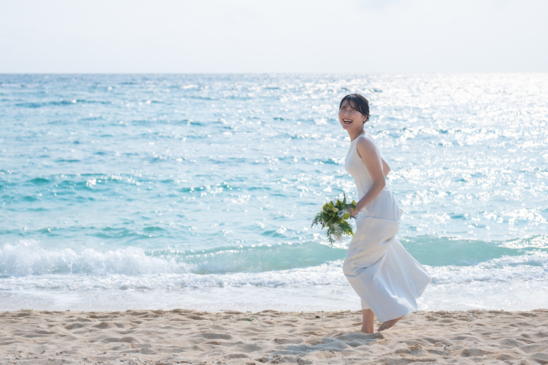 裸足で波打ち際を無邪気に楽しむ新婦様