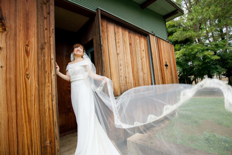 ドレスのレースとお揃いのマリアベールが風に舞って