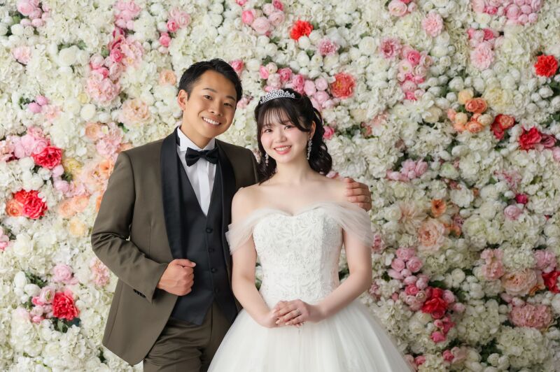 一面の花壁をバックに魅せるフレッシュな笑顔