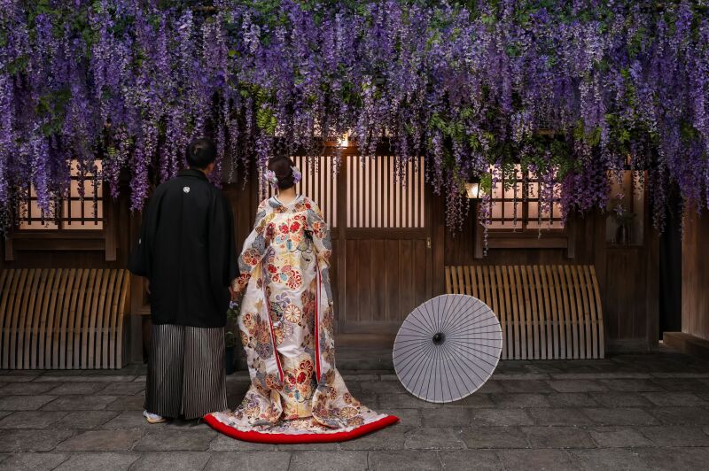 藤棚の下で和傘を添えた後ろ姿のシーン