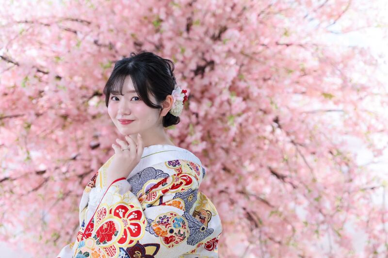 桜の背景に美しく映える新婦様のソロカット
