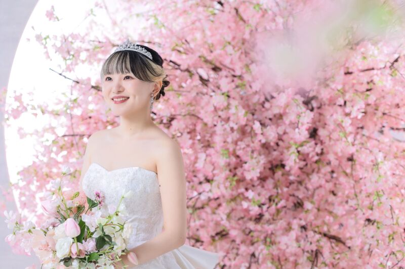 桜背景に映えるティアラと優しい微笑み